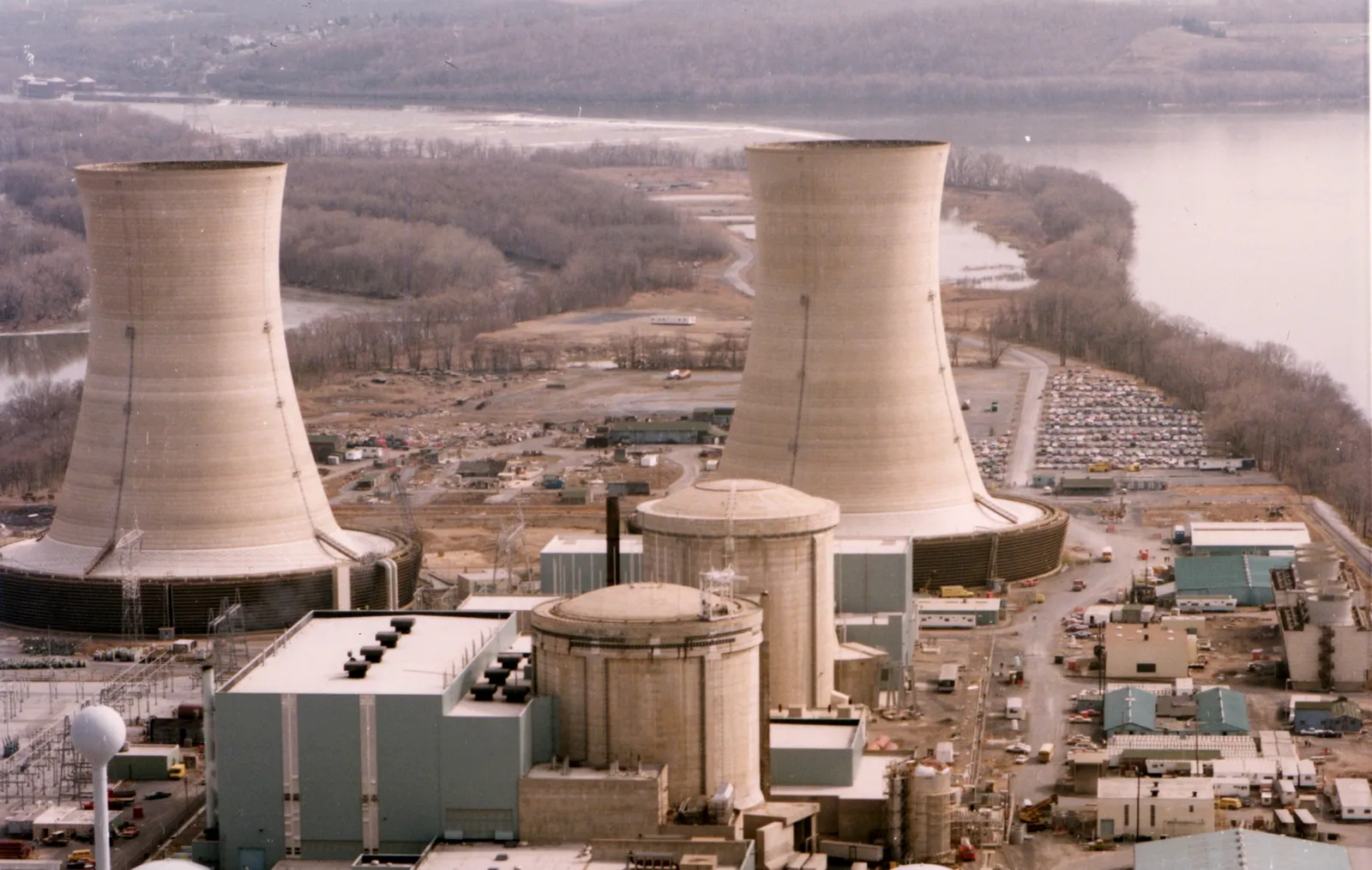 Aerial photo of the Three Mile Island nuclear plant: two cooling towers and the reactor buildings on an island in the Susquehanna River.
